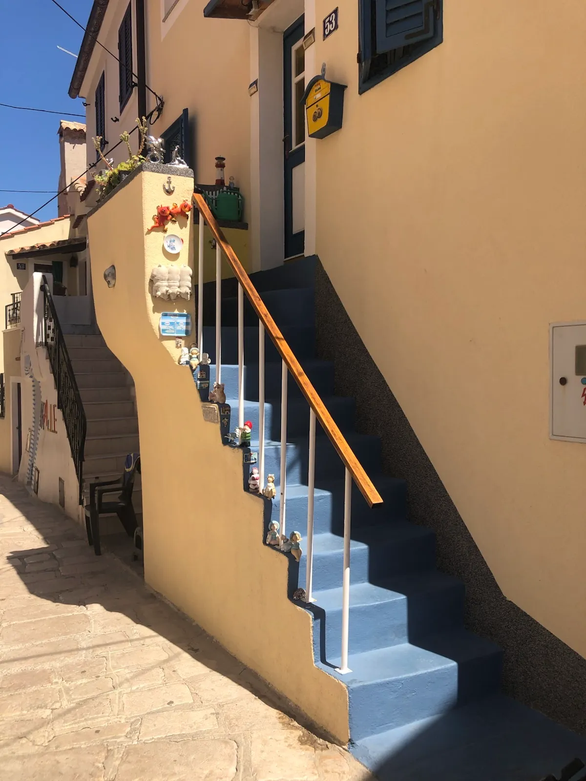 Narrow stone lane and colourful house details in old Baška
