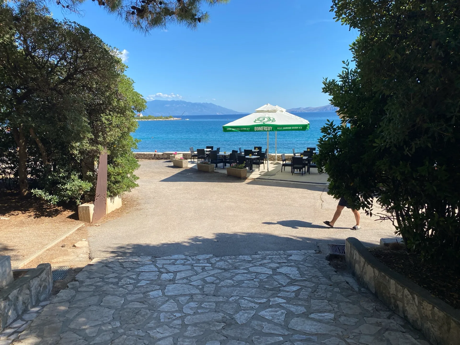 Shaded path through greenery leading toward Lišanj Beach