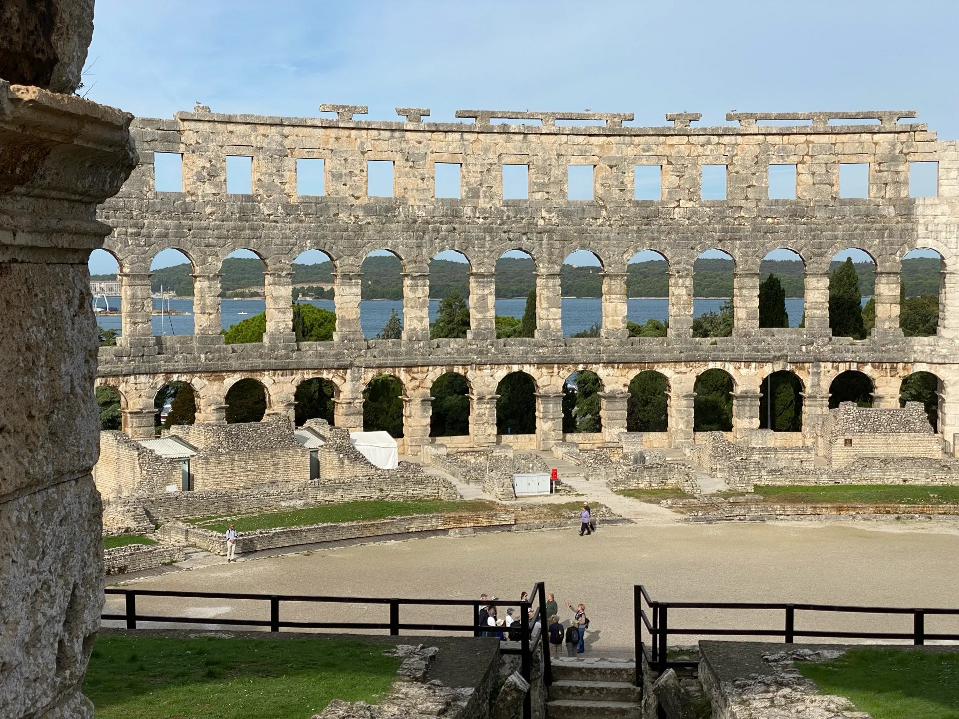 Adriatic view framed by the stone arches of Pula Arena